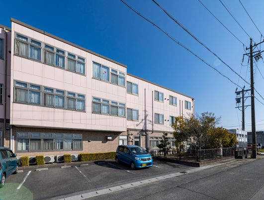 ピンク色の平屋建て建物