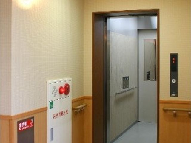 エレベーター前の廊下 エレベーター このエレベーターは、スムーズに移動をサポートします。木目調の落ち着いた廊下が印象的です。