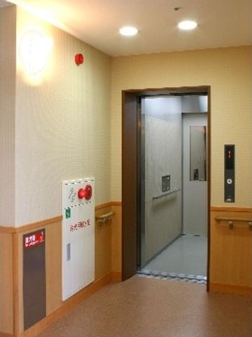 エレベーター前の廊下 エレベーター このエレベーターは、スムーズに移動をサポートします。木目調の落ち着いた廊下が印象的です。