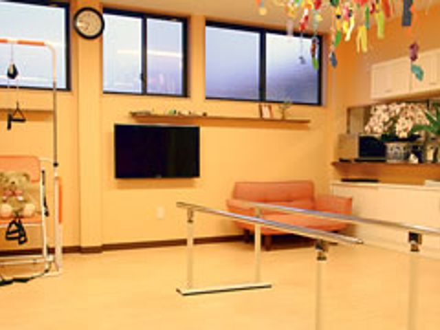 リハビリ用具が並ぶ部屋 機能訓練室 機能訓練用の設備が整った明るい部屋です。日中、自然光が差し込み、リラックスしてリハビリができます。
