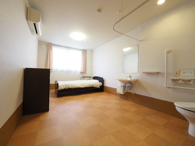 洋室の居室イメージ 個室 広々とした居室で、必要な設備が整っており、生活しやすい環境が保たれています。窓から自然光が入り、居心地の良い空間です。