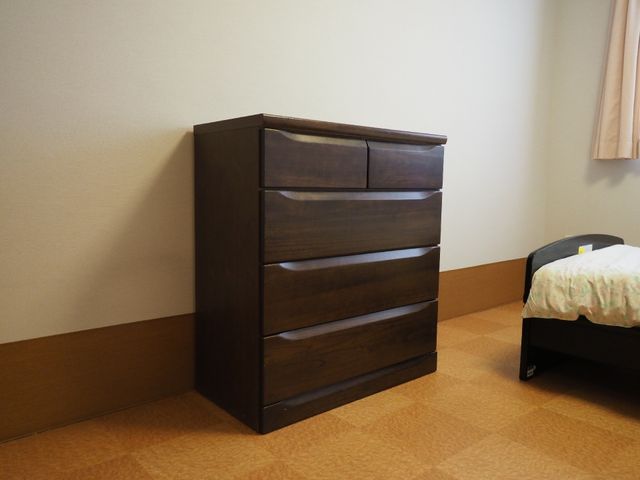 居室の家具とベッド 個室内のタンス シンプルで落ち着いた色合いの居室です。日々の生活に必要な家具が整っており、快適な空間をご提供しています。