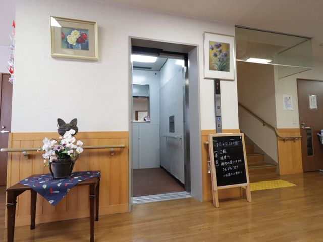 エレベーター付きの廊下 エレベーター 花々と絵画が飾られた廊下は、明るく温かみのある印象です。この場所では、日々の移動も穏やかなひとときを感じながら行えそうです。