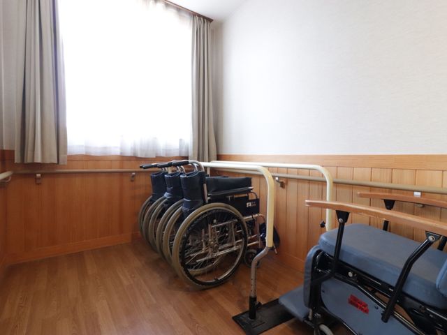 バリアフリーの居室 リハビリスペース 手すり付きで安全を考慮した居室です。車椅子やリハビリ用の機器も配置され、快適な環境が整っています。