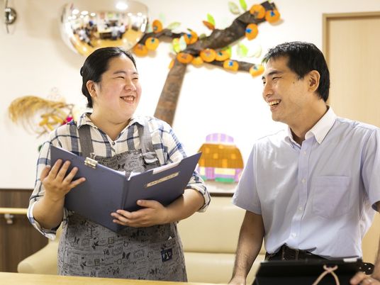 笑顔で話す職員と利用者のリビング  
