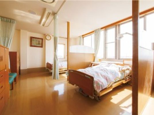 明るい居室のベッドと窓際の空間  