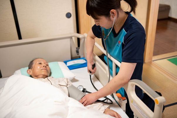 血圧を測る看護師と利用者