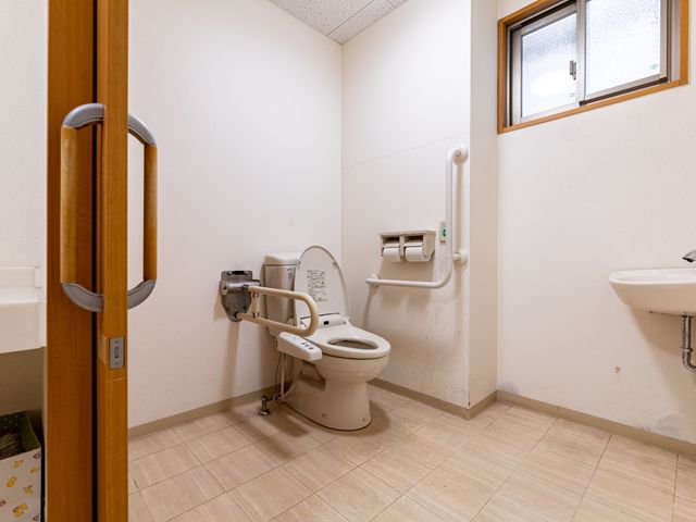 バリアフリー設計のトイレ トイレ 手すりが付いた清潔感あるトイレで、どなたでも安心してご利用いただけるように配慮されています。