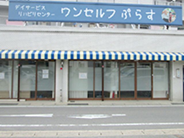 施設の看板と入口 外観 来訪者を温かく迎える、落ち着いた色調の施設です。魅力的な仕事環境を見つけられるかもしれません。