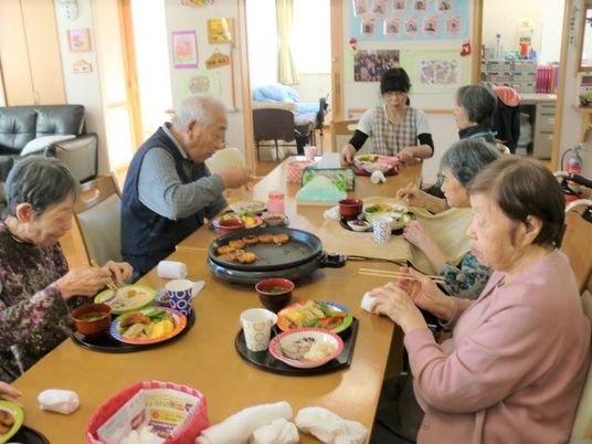 食事を共にする笑顔の人々