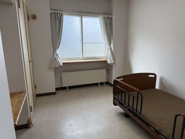 窓際の明るい居室 居室 自然光が差し込む広々とした空間です。シンプルな家具配置で落ち着いた雰囲気が漂っています。