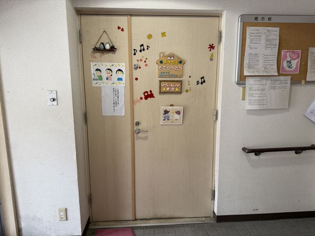 掲示物と装飾の壁 掲示物 壁が子どもたちのイラストや飾りで明るく装飾されています。掲示物には施設の日常が感じられます。