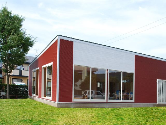 赤と白の建物外観 外観 大きな窓から自然光がたっぷりと入る、快適な作業環境を提供する建物です。