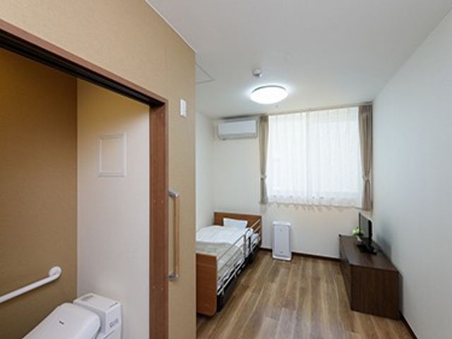 明るい居室 居室   窓から自然光が入る、すっきりとした居室です。ベッドや収納家具があり、落ち着いて過ごしやすい空間です。