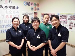 笑顔のスタッフが並ぶ掲示板前  