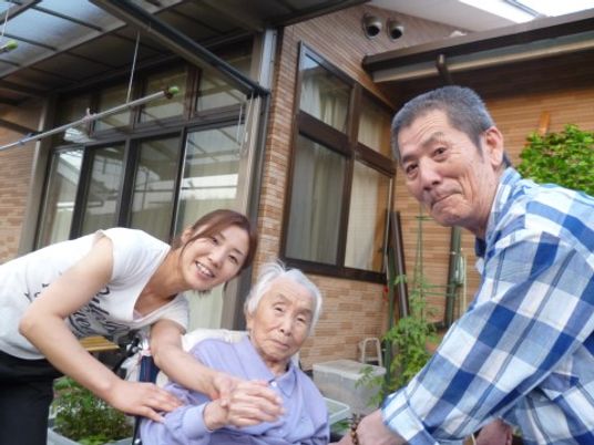 笑顔の三人と建物