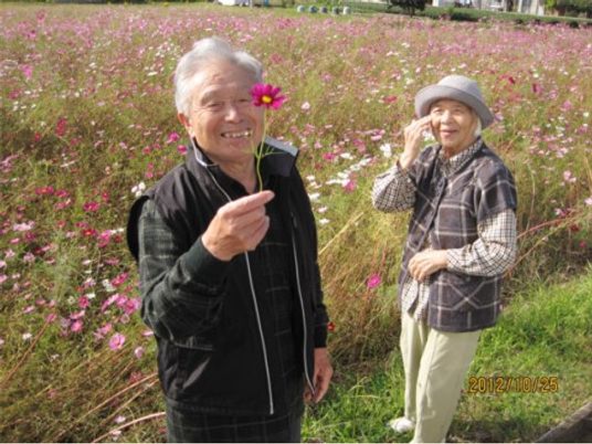 笑顔の高齢者と花畑