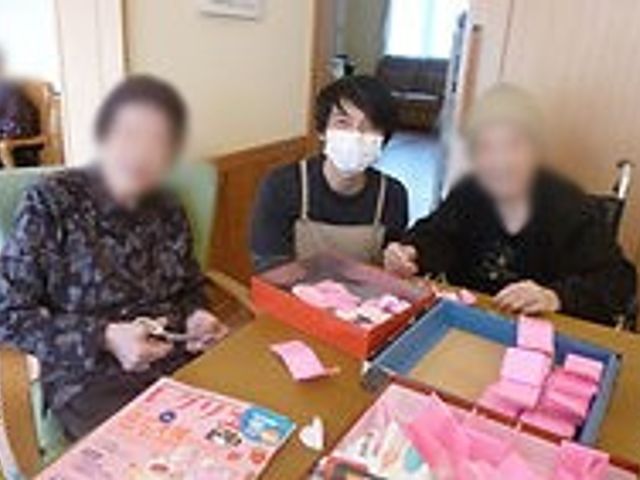 活動中の室内 居室 大きなテーブルでアクティビティに参加しています。みんなで楽しい時間を過ごせる空間です。