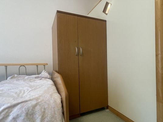 木製クローゼットとベッドのある部屋