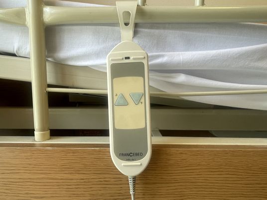 リモコンが掛けられたベッド