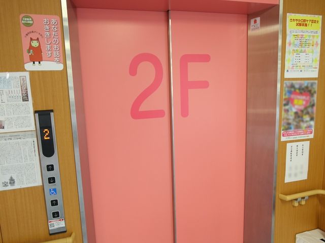 ピンクのエレベーター扉 エレベーター 床番号が大きく表示されたエレベーター前です。使いやすさに配慮された設計で、安心して業務に取り組めます。