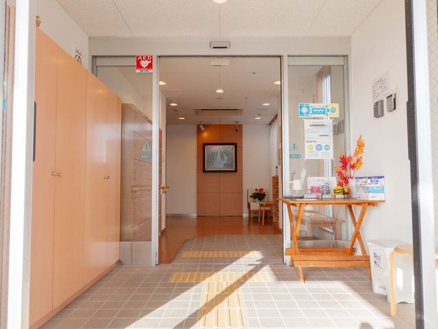 エントランスの様子 玄関 清潔感のある開放的な受付エリアが皆さんをお迎えします。心地よい待合スペースで、明るい雰囲気の中でご来訪される方々をお待ちいたします。