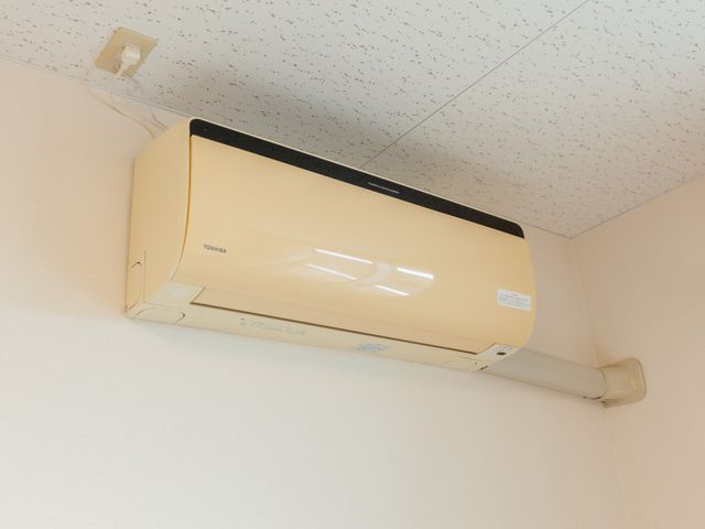 部屋のエアコン エアコン 清潔感あふれる部屋に設置されたエアコンです。一年中快適な環境を提供し、利用者の方々の健康管理をサポートします。