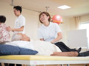 笑顔のスタッフと患者の訓練風景