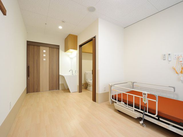 清潔で広々とした居室 居室 広々とした空間の居室で、明るい木目調の床と快適なベッド配置が特徴です。