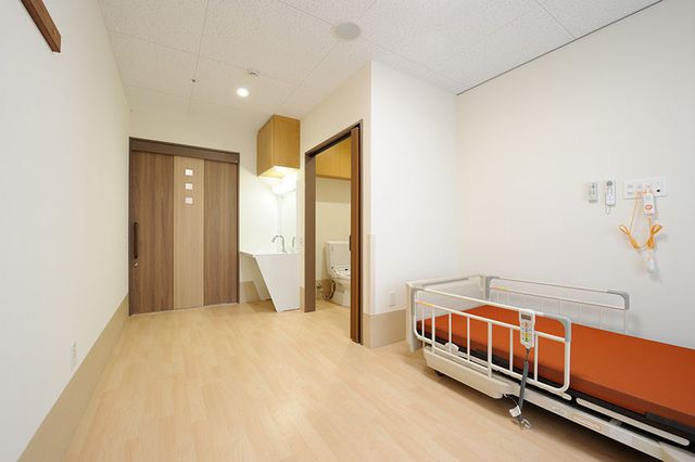 清潔で広々とした居室 居室 広々とした空間の居室で、明るい木目調の床と快適なベッド配置が特徴です。