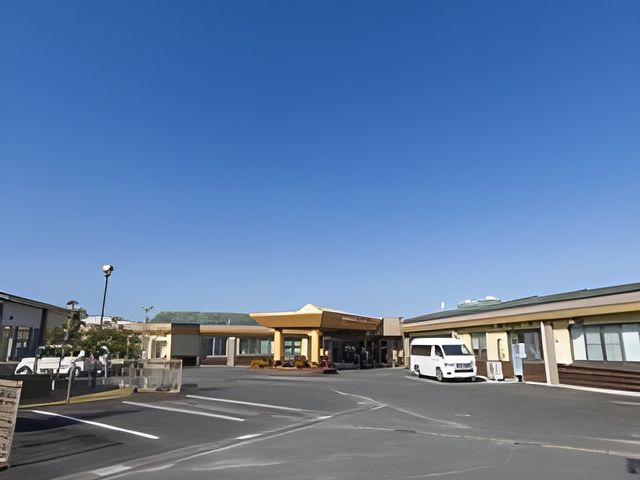 青空の下の平屋の外観 外観 青空の下、フラットでアクセスしやすい施設です。駐車場も広く快適に利用できます。
