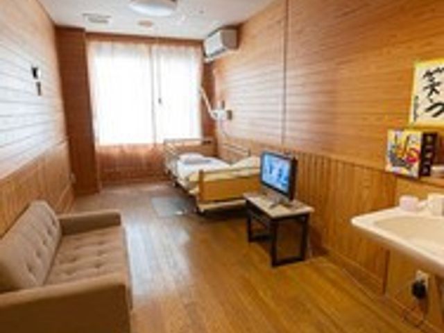 明るい個室の居室 居室   木の温もりを感じる個室は、穏やかな気持ちで過ごせる空間になっています。ベッドやソファも完備されています。