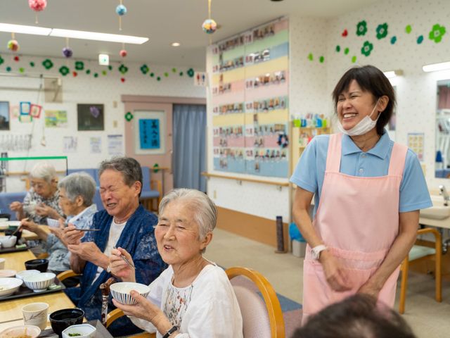 笑顔溢れる職場の様子 食堂 笑顔で接するスタッフの様子が、利用者との心温まる関係を築ける職場であることを示しています。
