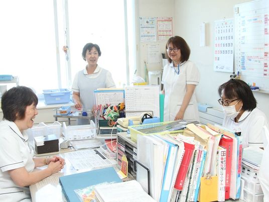 スタッフが集まる明るい事務室  