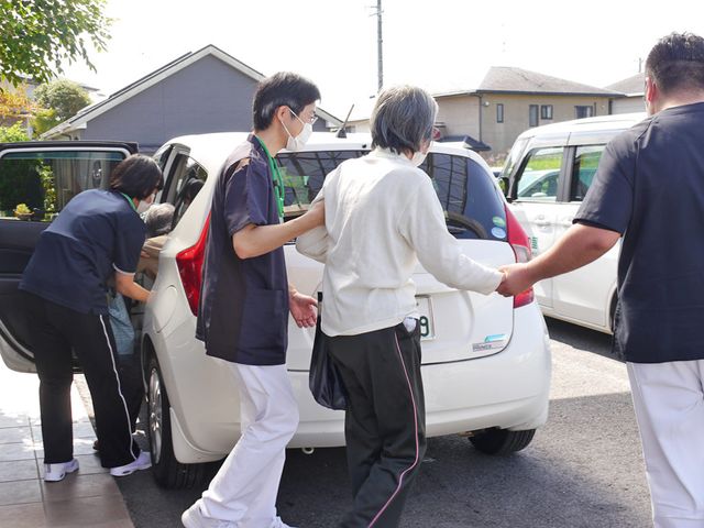 スタッフと利用者の様子 外観 送迎のサポートをする様子です。安心して通える環境を整えております。