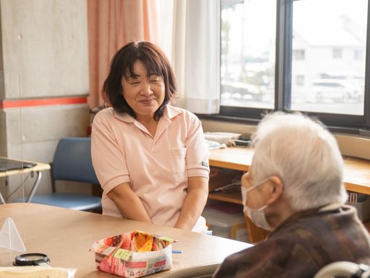 対話するスタッフと入居者、居室