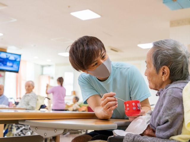 スタッフが利用者に対応 ダイニングルーム スタッフと利用者様の積極的な交流があり、やりがいのある環境で働ける様子がうかがえます。