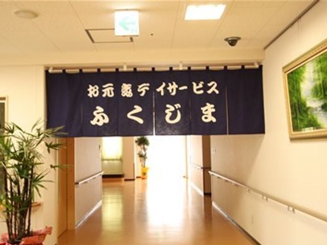 廊下に掲げられた横断幕 デイサービス 明るく清潔感ある通路に「おもてなしダイナミズム」の横断幕が掲げられ、訪れる方々を暖かく迎えています。