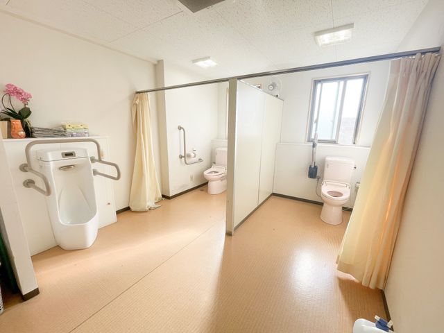 明るいケア施設の浴室 トイレ 手すり付きの広々とした洗面・トイレスペースです。清潔感があり、日当たりもよく、利用者の方々の快適な日々を支えています。
