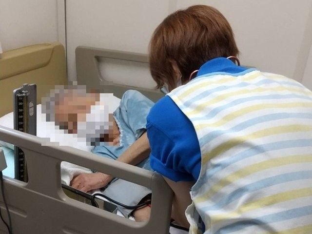 入居者を世話する場面の居室 居室   穏やかな環境の中で、スタッフが親身になって入居者をサポートしています。温かみのある時間を過ごせる空間です。