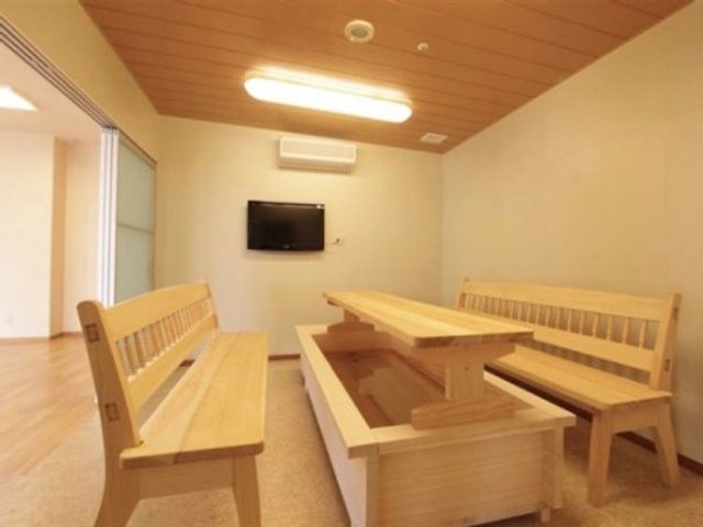 木製ベンチのある休憩室 足湯コーナー シンプルな造りの休憩スペースでは、木製のベンチで安らぎのひと時を過ごすことができます。壁に掛けられたテレビからは情報が提供され、静かな環境が保たれています。