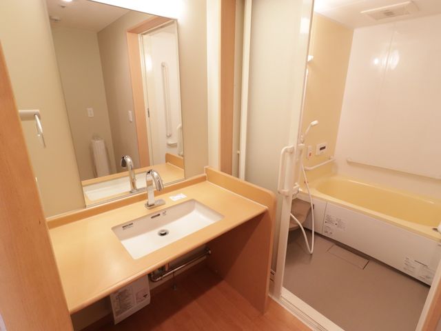 バリアフリー浴室設備 洗面所 手すり付きの安全設計浴室で、利用者の快適な生活を支えます。洗面台も広く使いやすさを考えたつくりです。