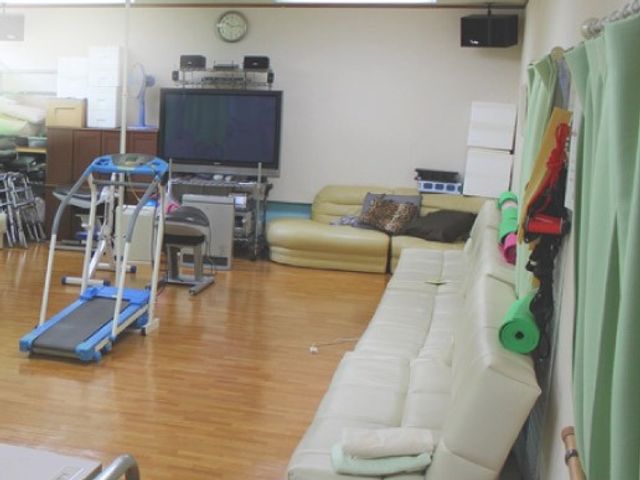 くつろぎスペース 機能訓練室 広々とした空間で、リラックスしながら運動療法が利用できます。ソファや運動器具が配置されています。
