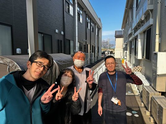 建物前での笑顔の集合写真