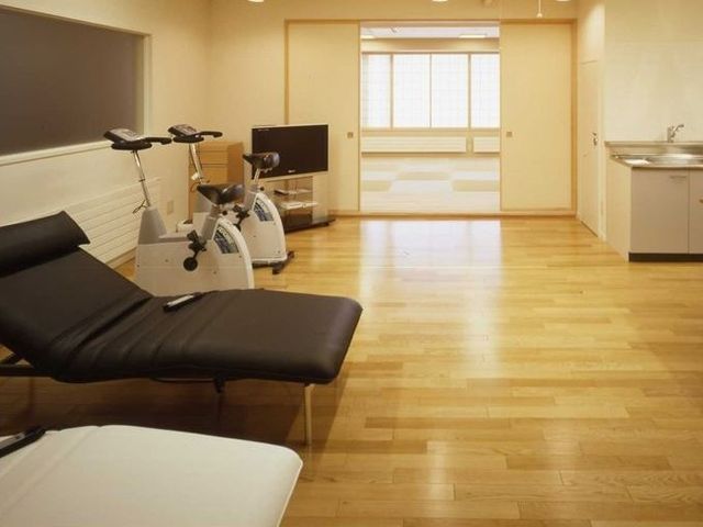 トレーニング機器のある部屋 訪問理美容サービス 木の温もりあふれる機能訓練室で、利用者様の日々の健康維持をサポートします。適切な設備を整え、安全な環境のもとで運動が行えます。