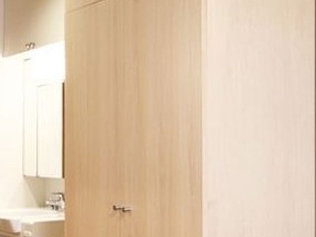 木製の洗面台付き洋室 収納スペース ゆとりある洋室には、すっきりとした洗面台が完備されております。日々の清潔を支え、快適な生活空間を提供しています。