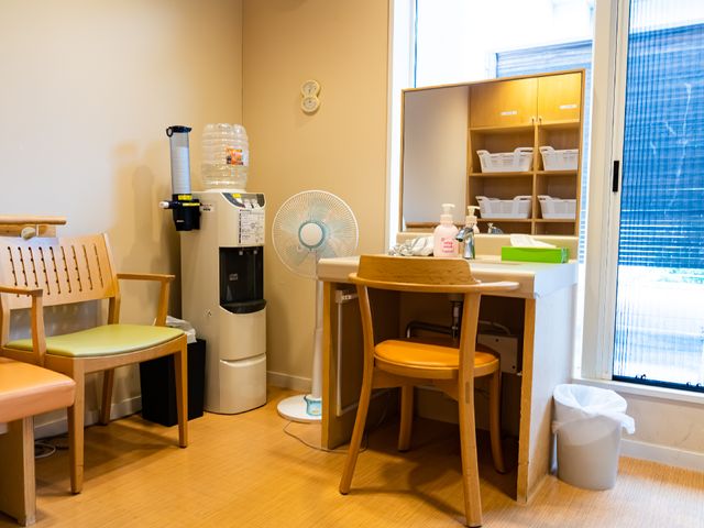 明るい休憩室の一角 脱衣所 落ち着いた色合いの休憩室で、水分補給や小休憩に最適な空間です。大きな窓からは自然光が差し込み、居心地良い時間を過ごせそうです。