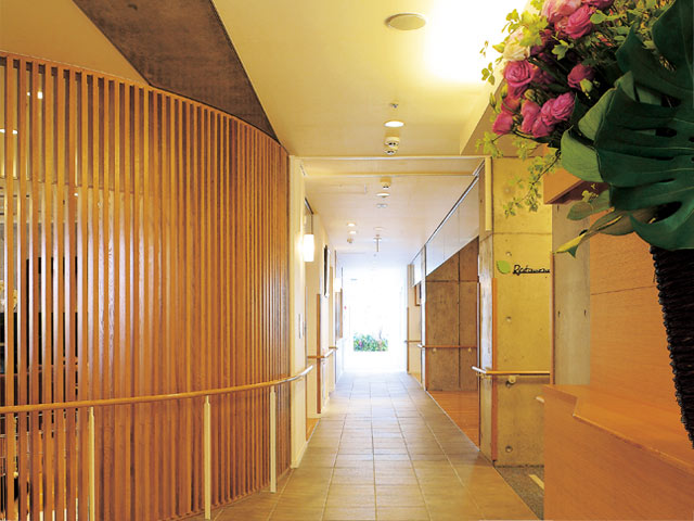 木目調の廊下 廊下   木目の格子が印象的な、明るく落ち着いた廊下です。奥まで見通しがよく、歩きやすい動線が感じられます。