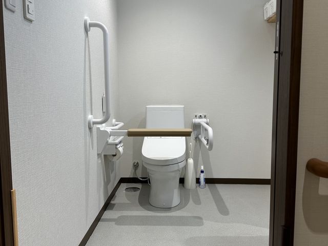 黄色い外壁の建物外観 トイレ 広々としたトイレで、介護のしやすさに配慮されています。清潔感あふれる環境でのお仕事を。