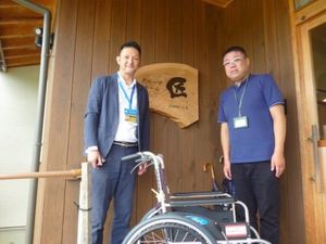 木の扉前に立つ男性2人のエントランス  